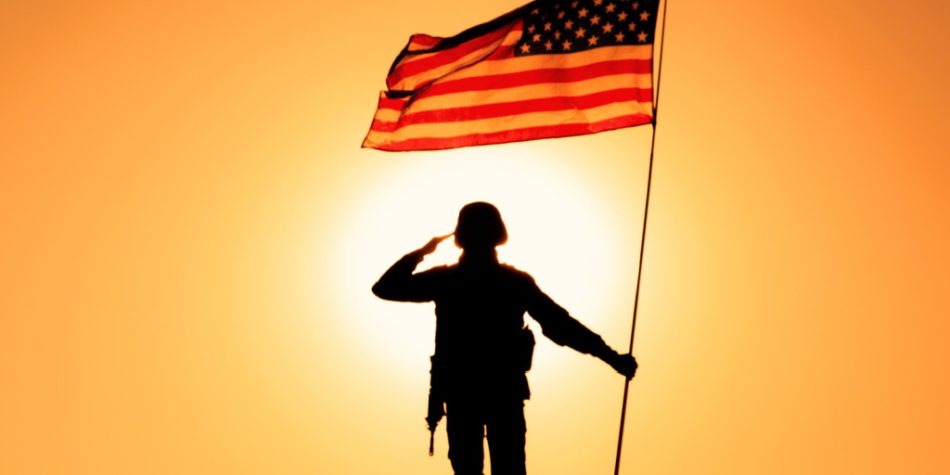 A resolute figure atop a mountain showcases a steadfast commitment and fidelity to country with a fluttering American flag.